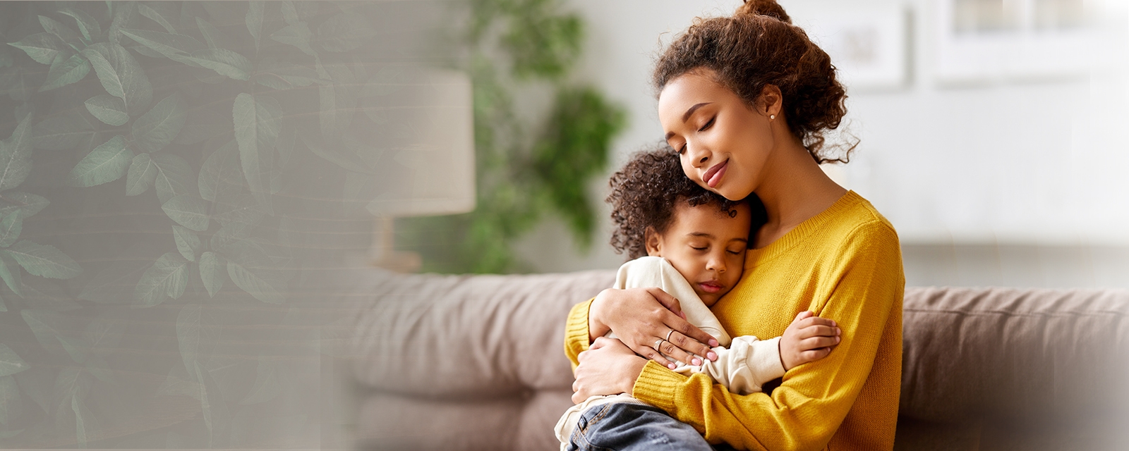 mother hugging toddler sitting on a couch